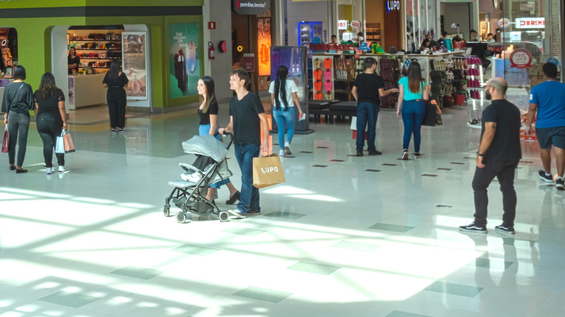 Visitantes com sacolas de compras no interior do Shopping São José